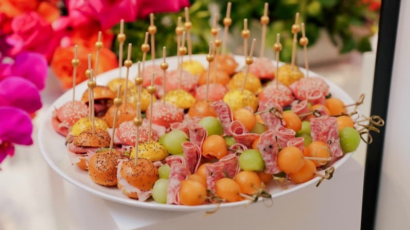 Colourful mini slider buns and melon ball skewers with salami styled with pink roses for an Adelaide cocktail party