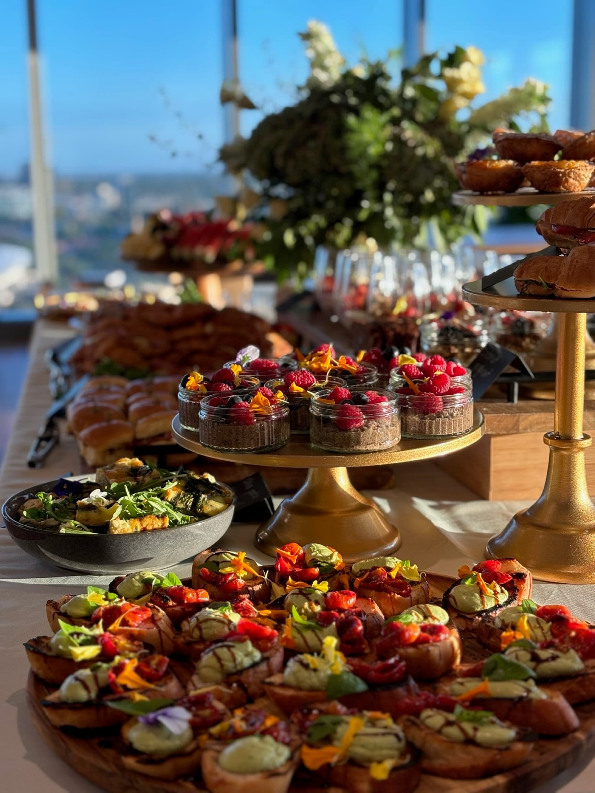 Catering spread at an Adelaide venue with bruschetta, cheesecakes, and florals